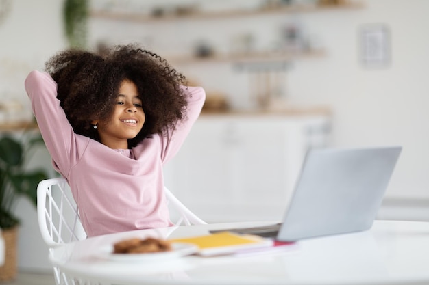 Niño afroamericano relajado sentado frente a la computadora