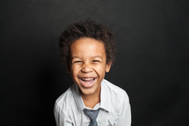 Niño afroamericano riendo en el fondo de la pizarra