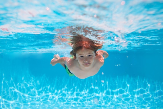 Niño bajo el agua nada en la piscina niño sano nadando y divirtiéndose bajo el agua actividad de los niños de verano