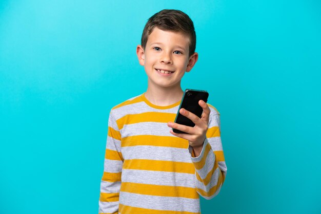 Niño aislado sobre fondo azul a través de teléfono móvil