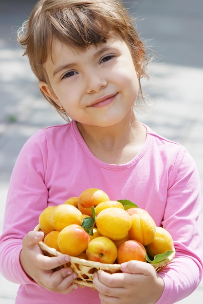 Niño con albaricoques.