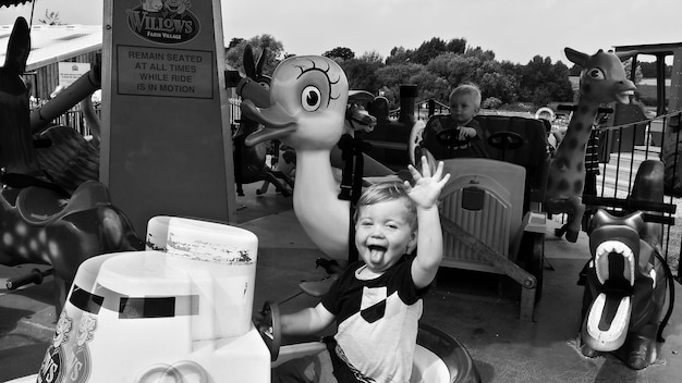 Foto niño alegre con el brazo levantado en el parque de atracciones