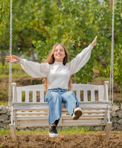 Foto niño alegre columpiándose en el columpio al aire libre, infancia.