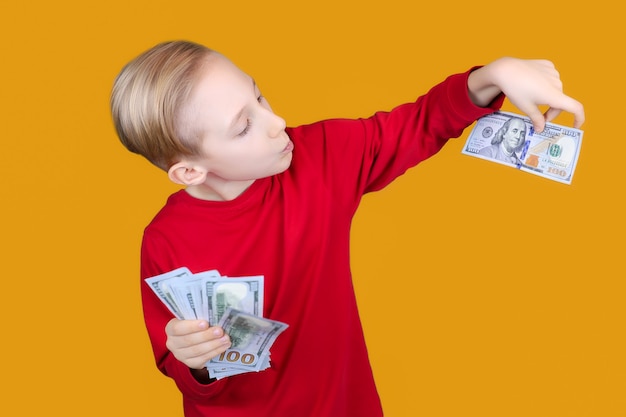 Un niño alegre con dinero en sus manos.