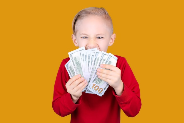 Un niño alegre con dinero en sus manos.