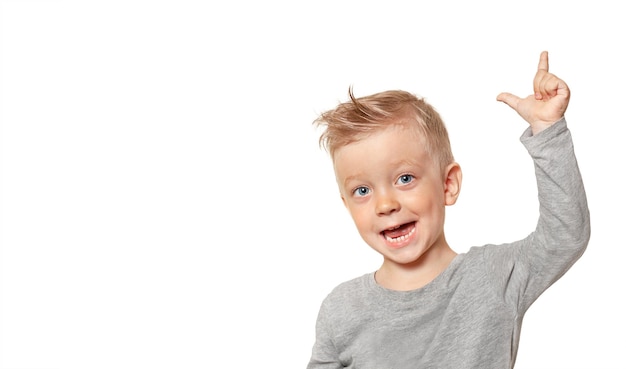 Un niño alegre y feliz está gritando algo y señalando con el dedo