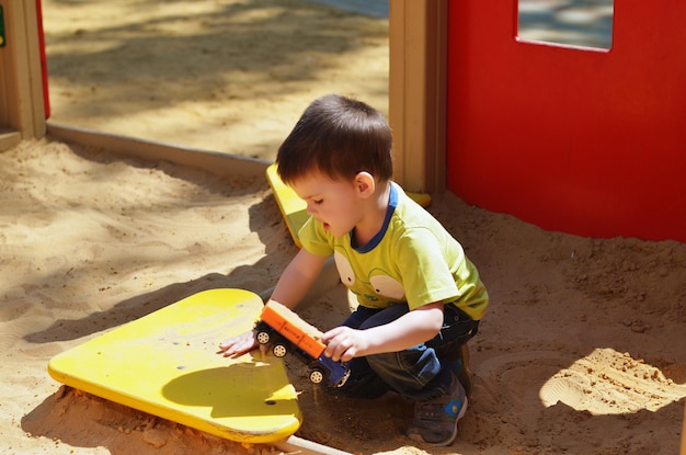 Niño alegre jugando en el parque, parque infantil, riendo en un paseo en un día. Estilo de vida familiar. Niños