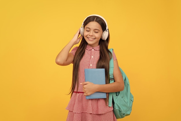 Niño alegre con mochila escolar música jovencita llevar mochila de regreso a la escuela