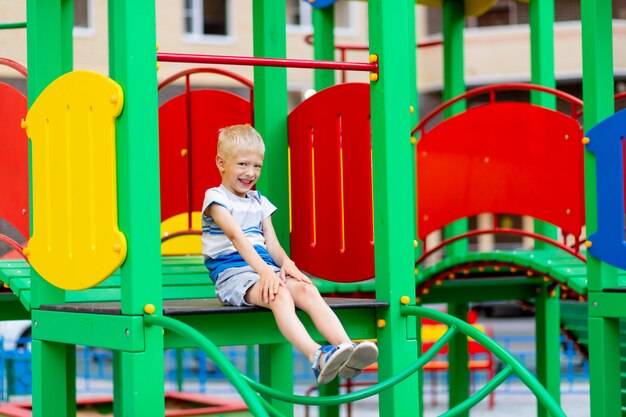 Un niño alegre en el patio de recreo en un día de verano.