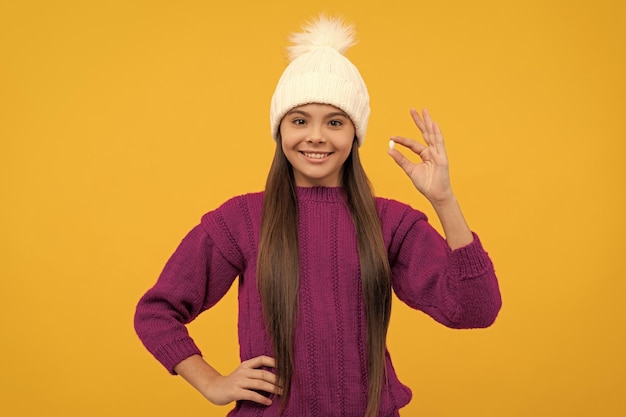 Niño alegre en sombrero de invierno con medicina de píldora