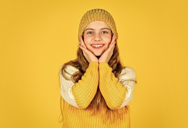 Niño alegre usar sombrero y suéter favorito infancia felicidad adolescente niña fondo amarillo niña en prendas de punto niño belleza y moda calentarse en la temporada de invierno pronóstico del tiempo frío