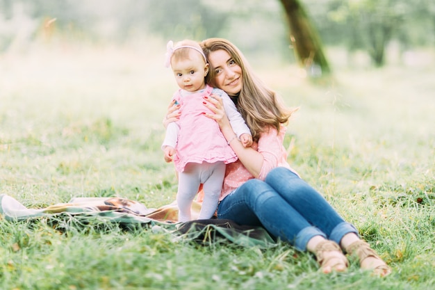 Niño alegre en vestido rosa y su madre