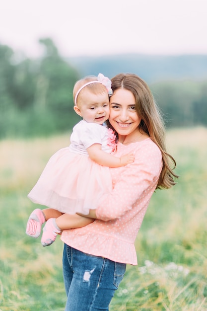 Niño alegre en vestido rosa y su madre