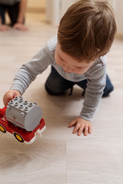 Foto niño de alto ángulo jugando con auto