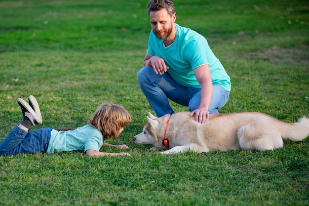 Niño con amigo mascota padre e hijo con perro pasando tiempo al aire libre