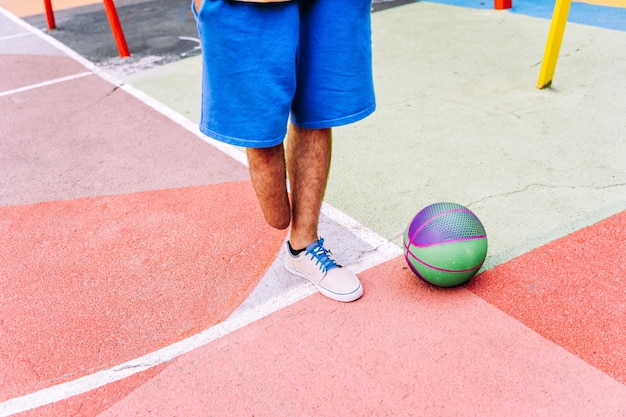 Foto niño amputado jugando baloncesto en el parque y haciendo deporte. concepto sobre discapacidad y persistencia