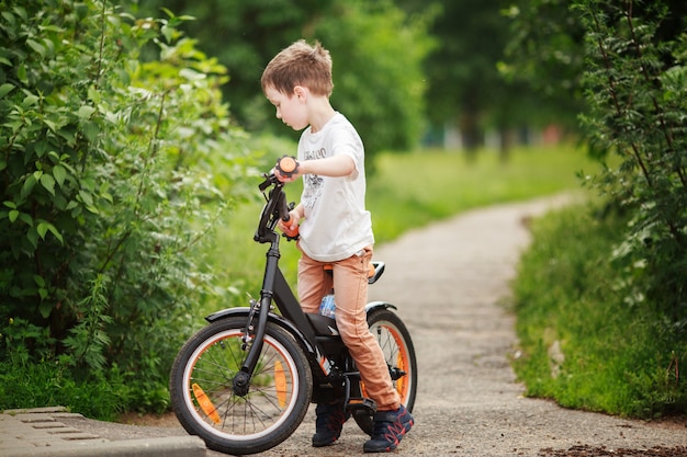 Foto el niño anda en bicicleta por la calle.