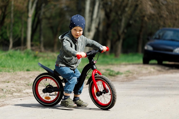 Niño andando en bicicleta en la calle aprendiendo a andar en bicicleta concepto