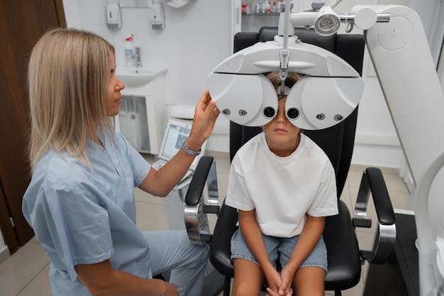 Foto niño de ángulo alto en el chequeo ocular