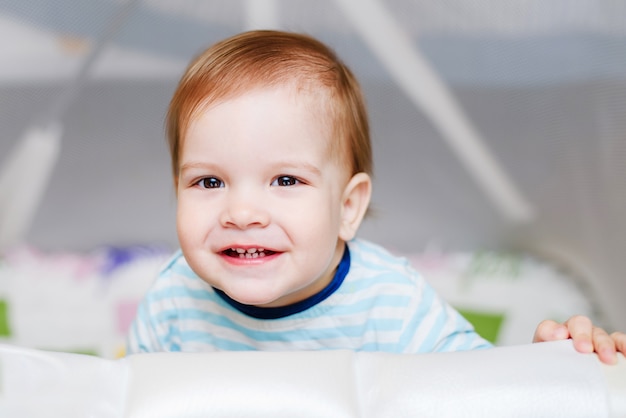 Un niño de un año está sentado en una arena.