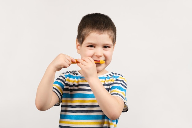 Un niño de años se cepilla los dientes con un cepillo de dientes.