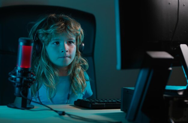 Niño aprendiendo en línea por la noche usando una computadora de escritorio en la sala de estar en casa Niño usando tecnología informática en casa