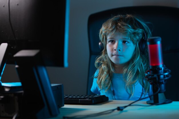 Niño aprendiendo en línea por la noche usando una computadora de escritorio en la sala de estar en casa Niño usando tecnología informática en casa