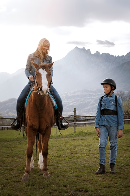 Foto niño aprendiendo a montar a caballo