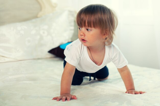 Niño arrastrándose en la cama grande