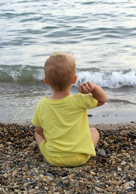 un niño arroja una piedra al mar