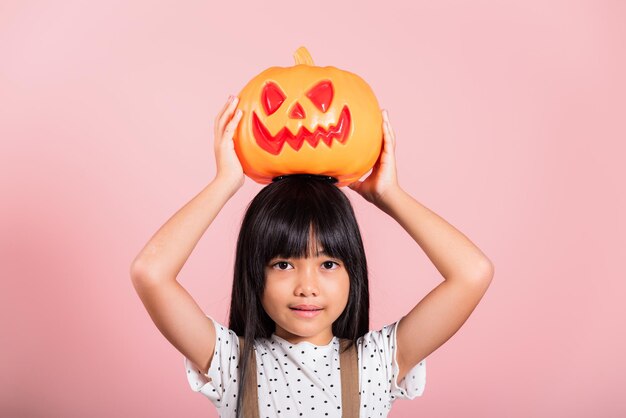 Niño asiático de 10 años con calabaza de Halloween tallada