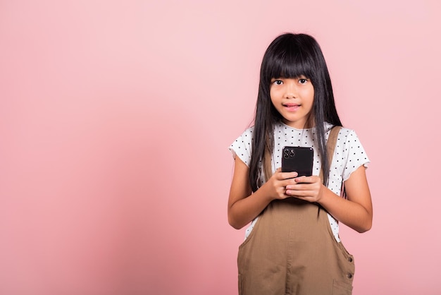 Niño asiático de 10 años disfrutando del uso de teléfonos móviles para redes sociales