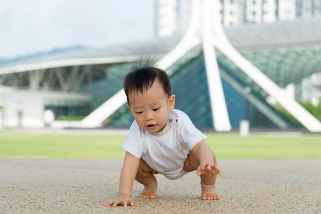 Niño asiático arrastrándose en el parque