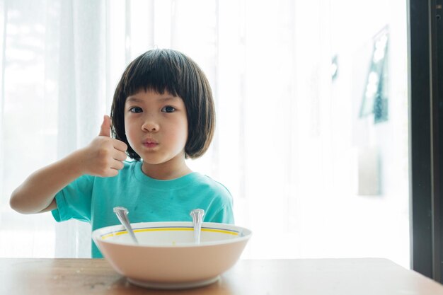 Niño asiático comiendo fideos con fondo borroso