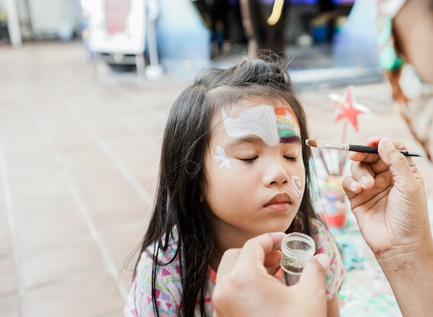 Niño asiático en edad preescolar con maquillaje de pintura facial