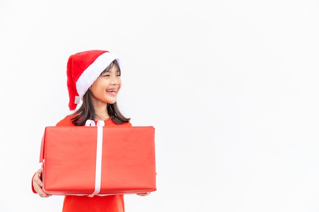 Niño asiático feliz en Santa sombrero rojo con regalos de Navidad. Tiempo de navidad sobre fondo blanco.