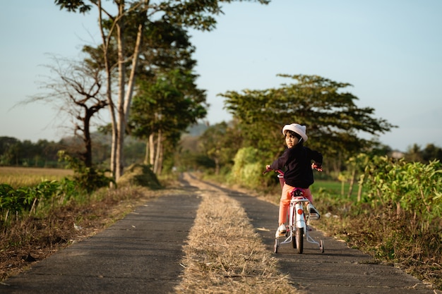 Niño asiático independiente montando su bicicleta