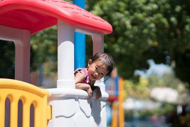 Niño asiático jugando en el patio de recreo