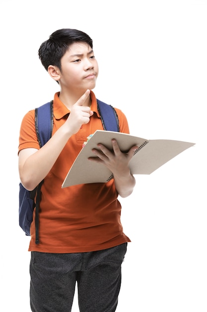 Niño asiático lindo con efectos de escritorio de la escuela en blanco.