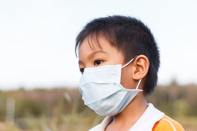 Niño asiático con una máscara de protección para prevenir el virus Corona