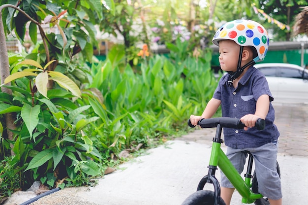 Niño Asiático montando una bicicleta