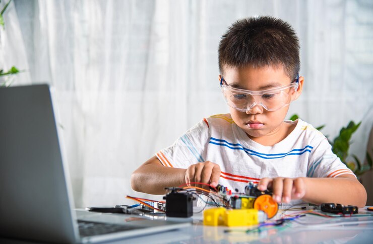 Foto niño asiático montando el proyecto de tareas del coche robot arduino en casa