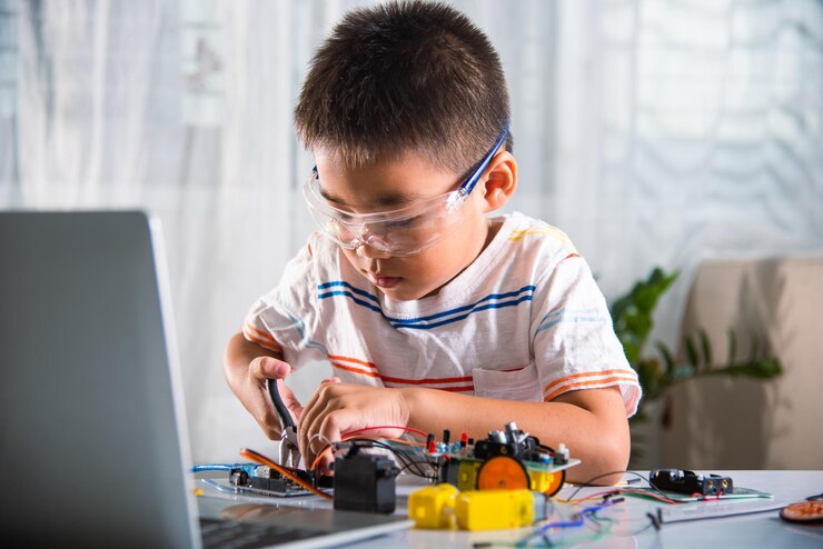 Foto niño asiático montando el proyecto de tareas del coche robot arduino en casa