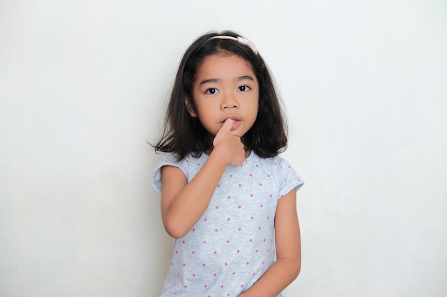 Foto niño asiático mordiéndose la uña del dedo pulgar concepto de mal hábito