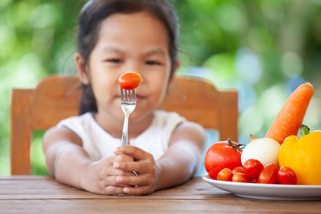 Foto a un niño asiático no le gusta comer verduras y se niega a comer verduras saludables