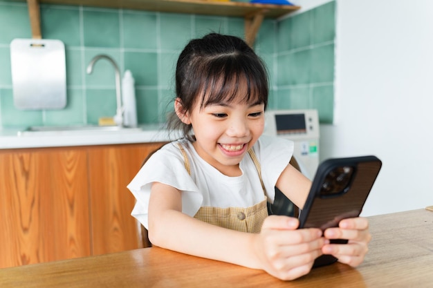 Niño asiático con smartphone en casa