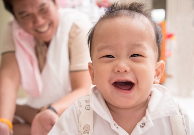 Niño asiático sonriendo con cara feliz