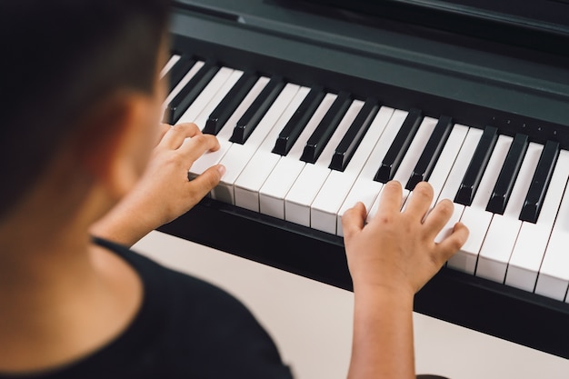 Un niño asiático tocando el piano