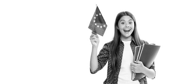 Un niño asombrado estudia en el extranjero, viaja y aprende un idioma extranjero. Una adolescente sostiene la bandera de la Unión Europea. Retrato de una colegiala.