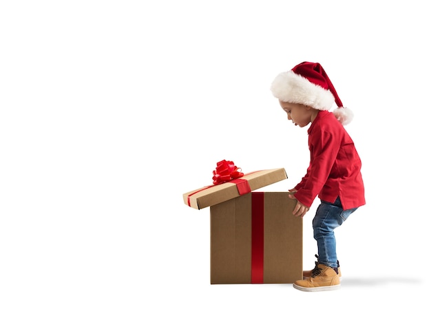 Niño asombrado por el gran regalo mágico de Navidad. Fondo blanco